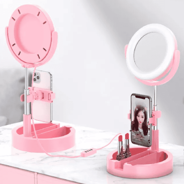 Pink foldable selfie stick with ring light and phone holder on marble surface by Clarify.pk