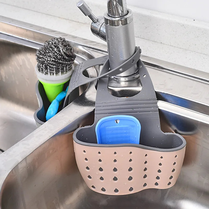 Clarify.pk sink hanging storage organizer in gray and beige holding cleaning brushes by kitchen faucet