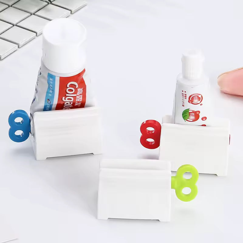 Plastic toothpaste tube squeezer with colorful winding keys holding partially used toothpaste tubes