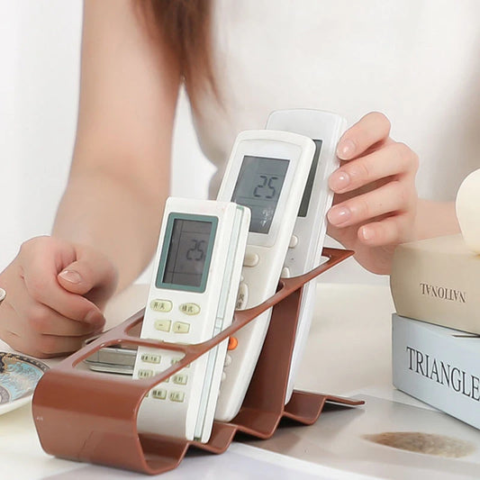 Brown TV remote stand holder organizing multiple white remote controls on a table