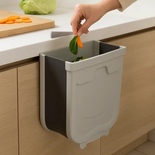 Wall mounted kitchen trash bin in gray attached to wooden cabinet for easy waste disposal