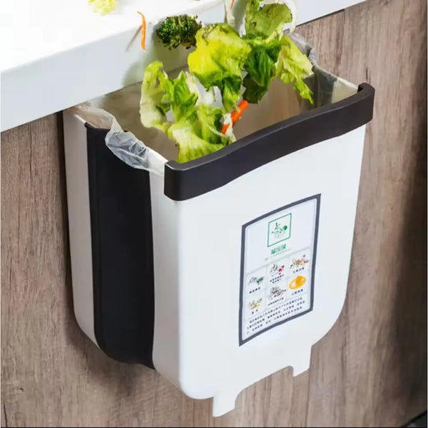 Wall mounted kitchen trash bin attached to cabinet with vegetable scraps inside