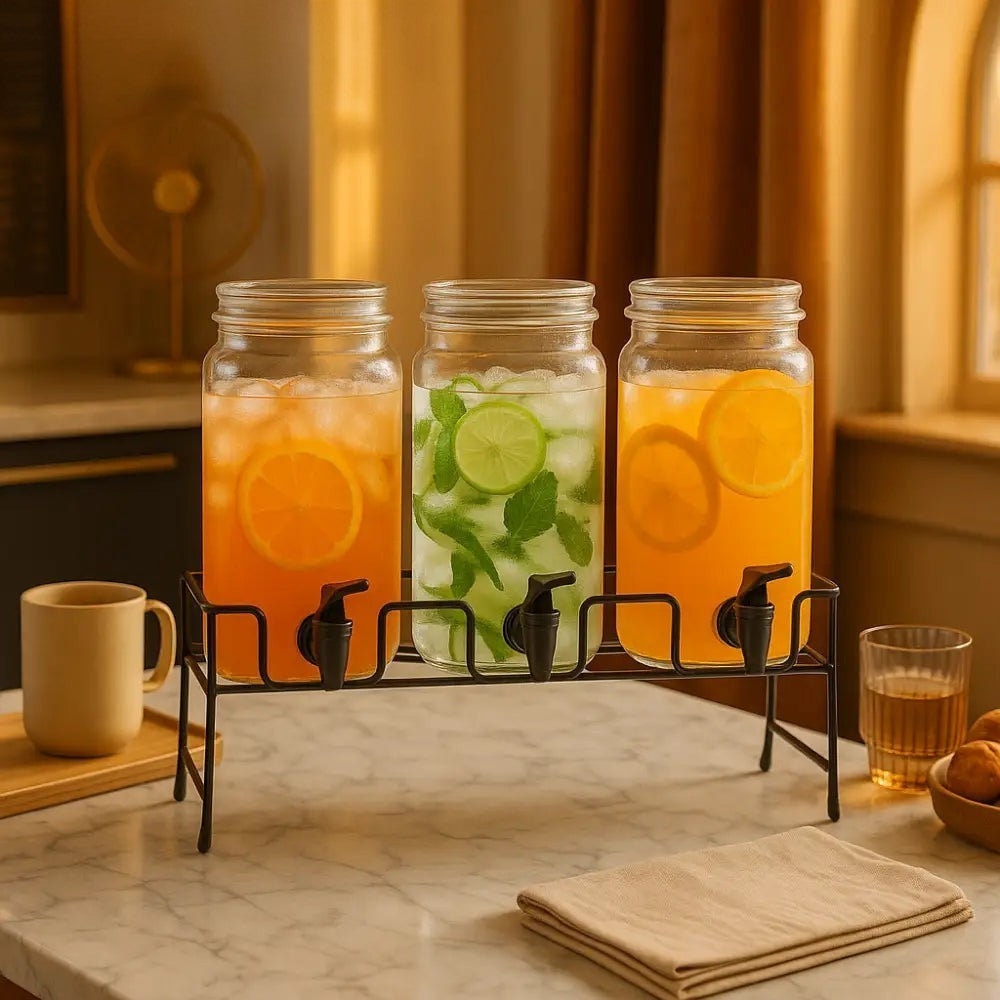 Clarify.pk triple beverage dispenser with three glass jars filled with refreshing citrus and mint drinks on a black metal stand