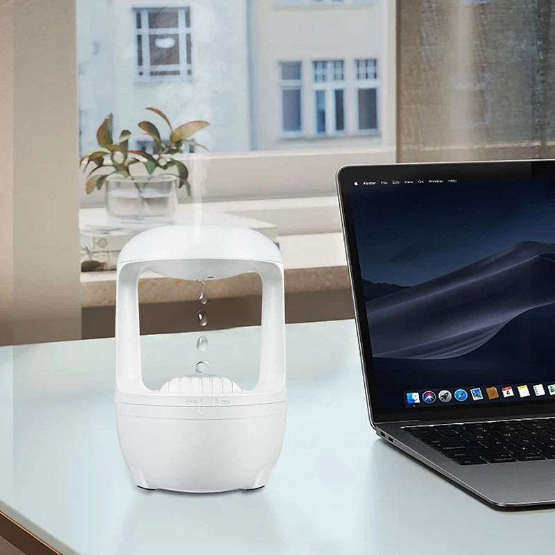 Glow in the dark air humidifier by Clarify.pk placed on desk next to laptop with mist coming out