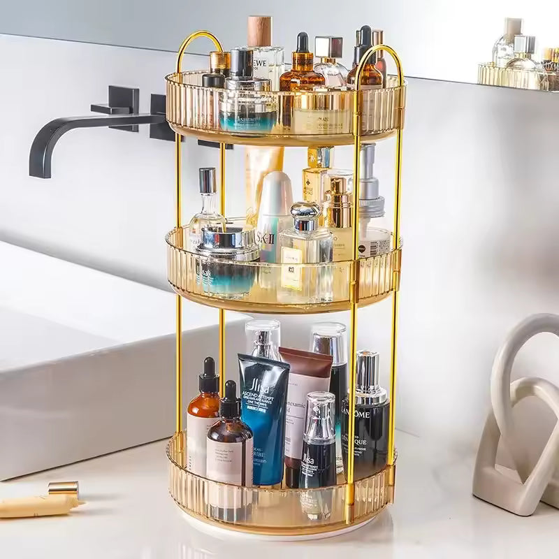 Gold 3 tier cosmetics organizer holding various skincare and perfume bottles on bathroom counter