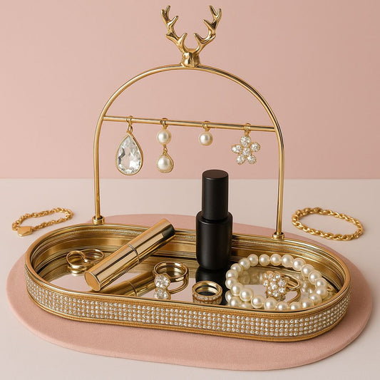 Elegant gold jewelry organizer tray with antler design holding earrings, rings, bracelet, and perfume bottle