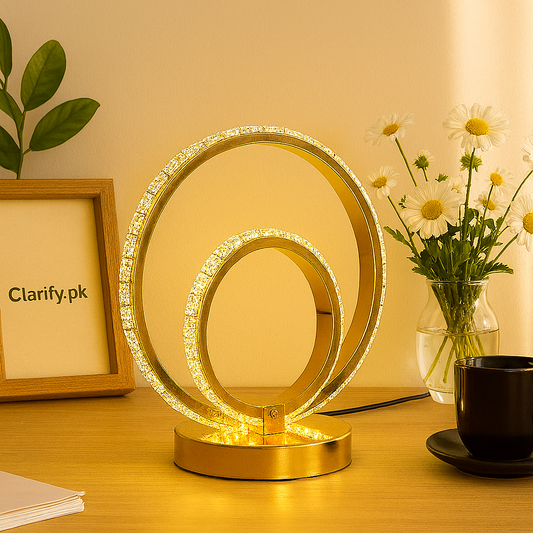 Modern gold LED bedside lamp with circular design illuminating a wooden table