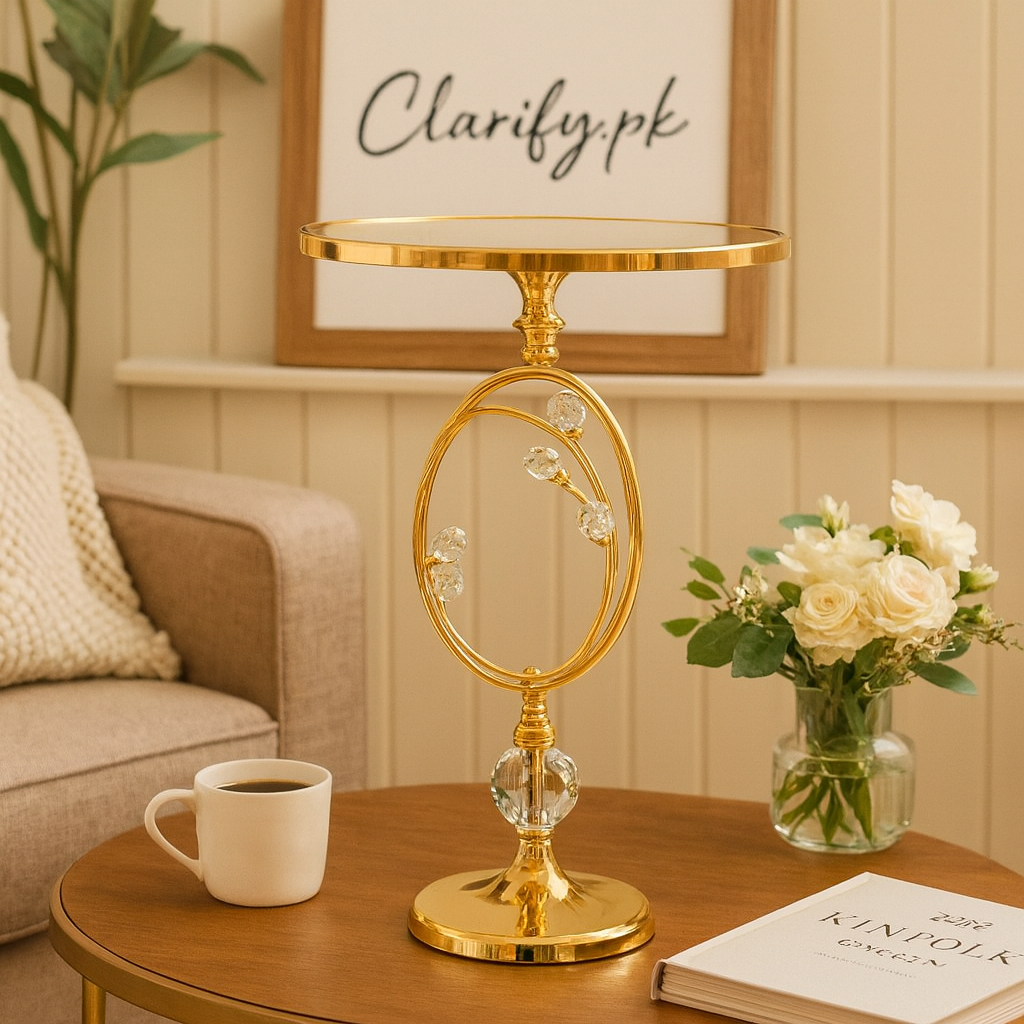 Elegant gold metallic display stand with floral accents on wooden table next to coffee cup and flowers