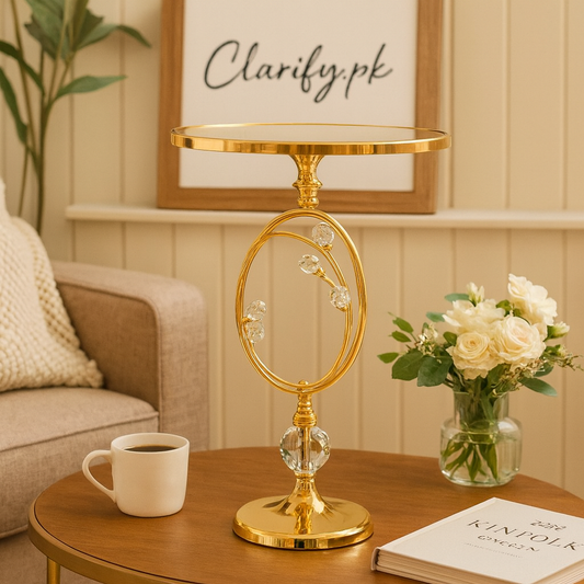 Elegant gold metallic display stand with floral accents on wooden table next to coffee cup and flowers
