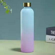 Clarify.pk gradient color outdoor water cup with pink and blue hues and gold cap on table near books