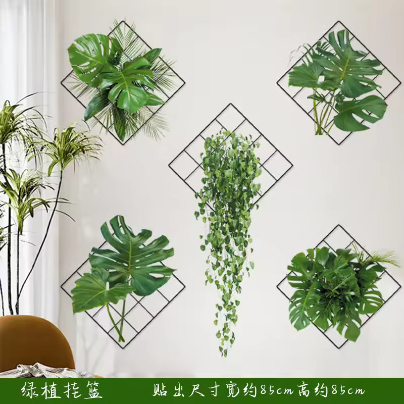 Green plant wall stickers with tropical leaves arranged on black diamond frames decorating a white living room wall