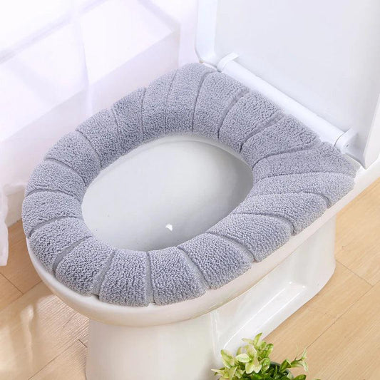 Gray washable toilet seat cover made of soft fabric fitted on a white toilet seat