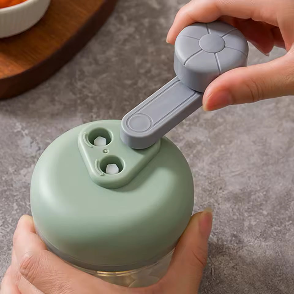 Green and gray hand pulled manual chopper garlic press being operated on a gray countertop