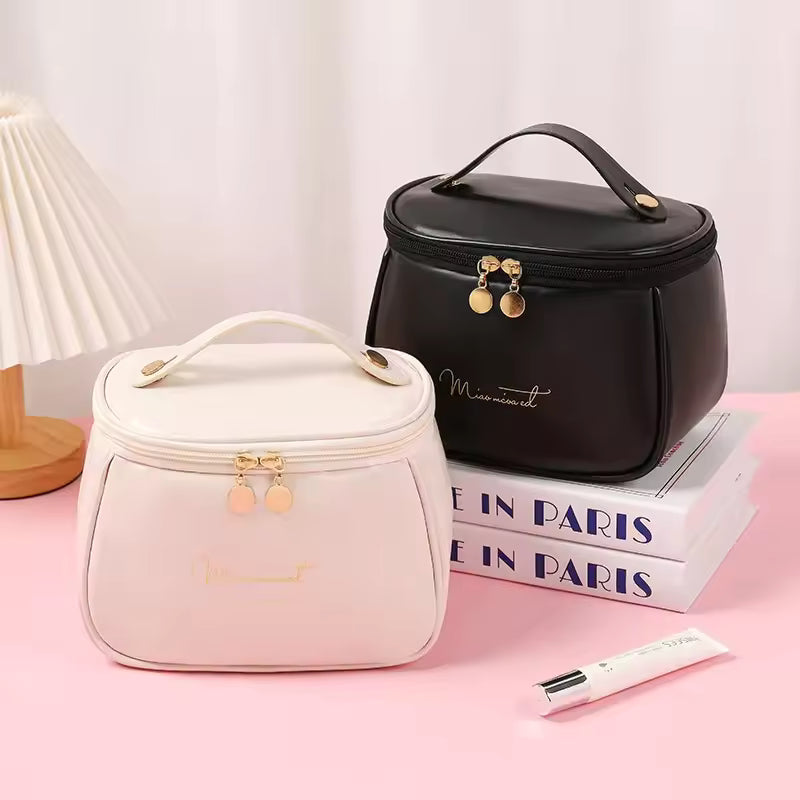 Clarify.pk PU leather handheld makeup wash bag in black and white with gold zipper pulls