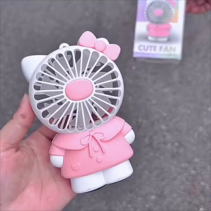 Hello Kitty handheld fan in pink outfit with bow held in hand by Clarify.pk