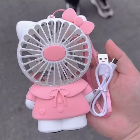 Hello Kitty handheld fan in pink and white with USB charging cable held in hand