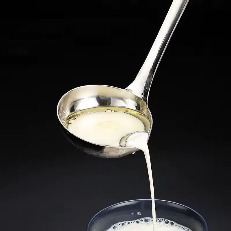 Clarify.pk stainless steel oil separator spoon draining liquid into glass cup on black background