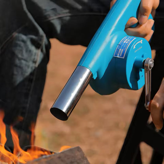 High temperature resistant hand blower in use with blue body and metal nozzle near outdoor fire
