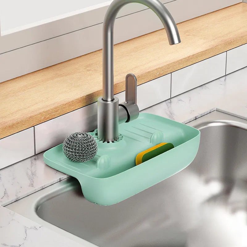 Clarify.pk silicone faucet mat in mint green holding a scrubber and sponge under kitchen faucet