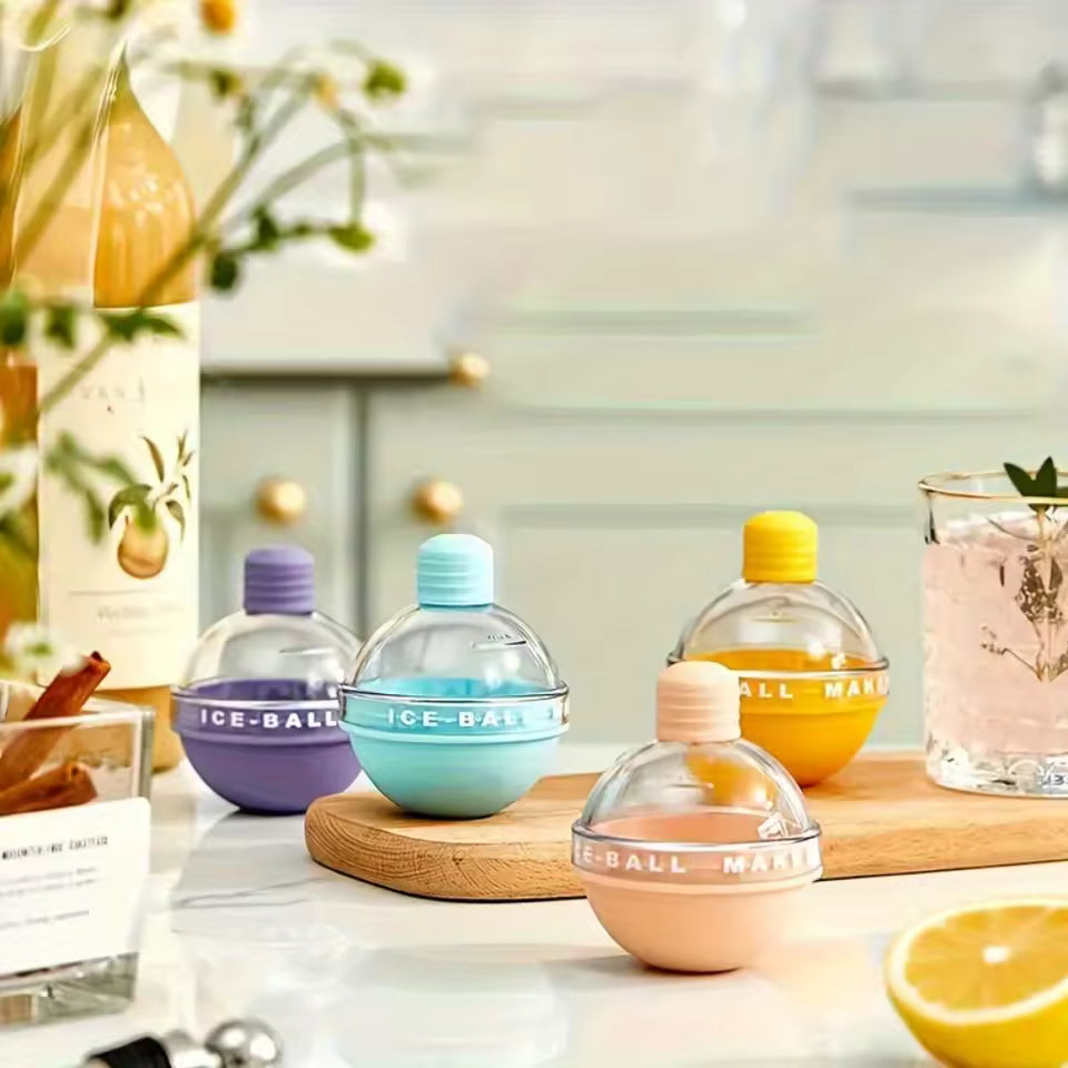 Colorful spherical ice molds in blue yellow purple and peach placed on a kitchen counter for ice cream makers