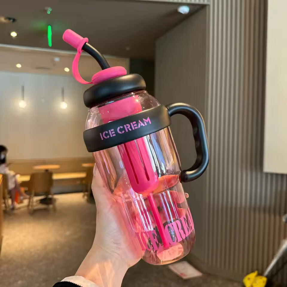 Clear pink large capacity plastic water bottle with black handle and ice cream design held in hand