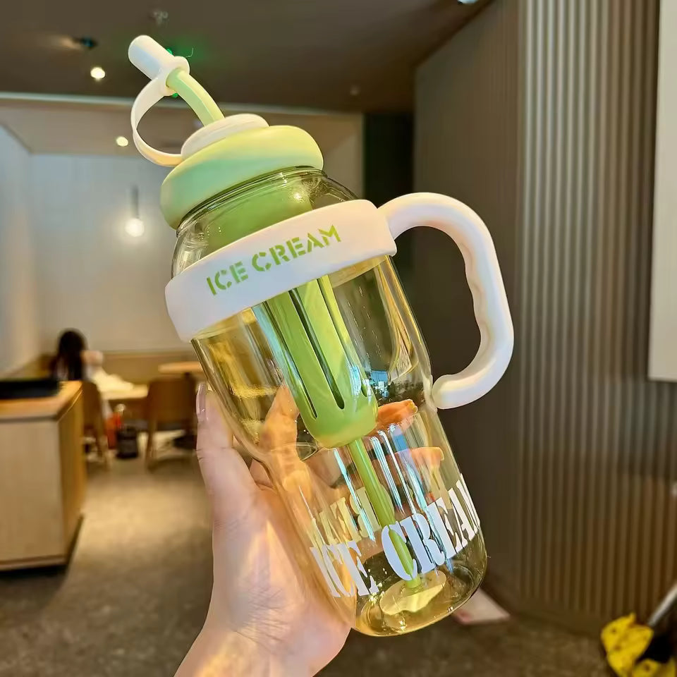 Clear large capacity plastic water bottle with green lid and handle labeled ice cream