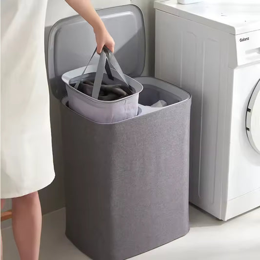 Gray Japanese style clothes hamper with removable inner basket next to washing machine