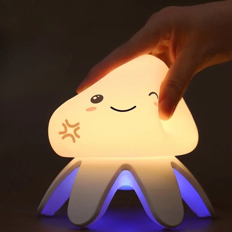 Cute jellyfish night light with soft glowing body and blue illuminated tentacles held by hand in dark