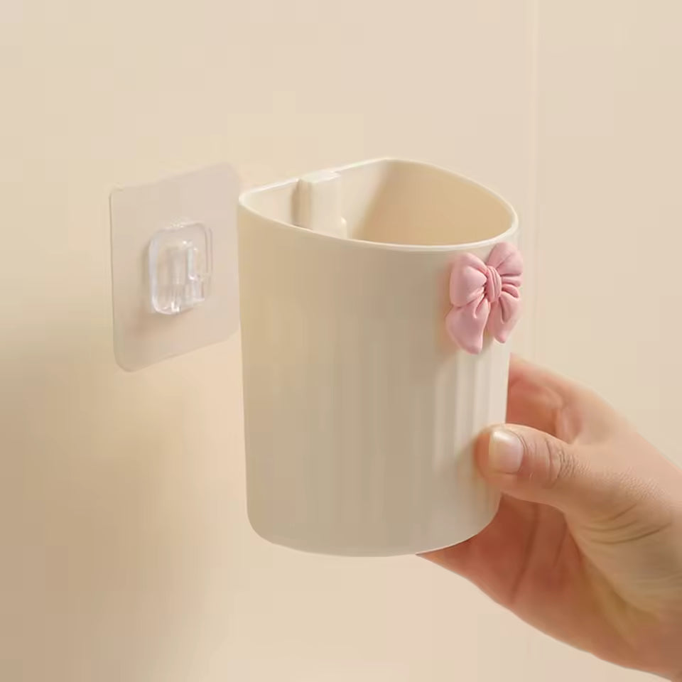 Kawaii pen holder for desk in white with pink bow decoration being attached to wall