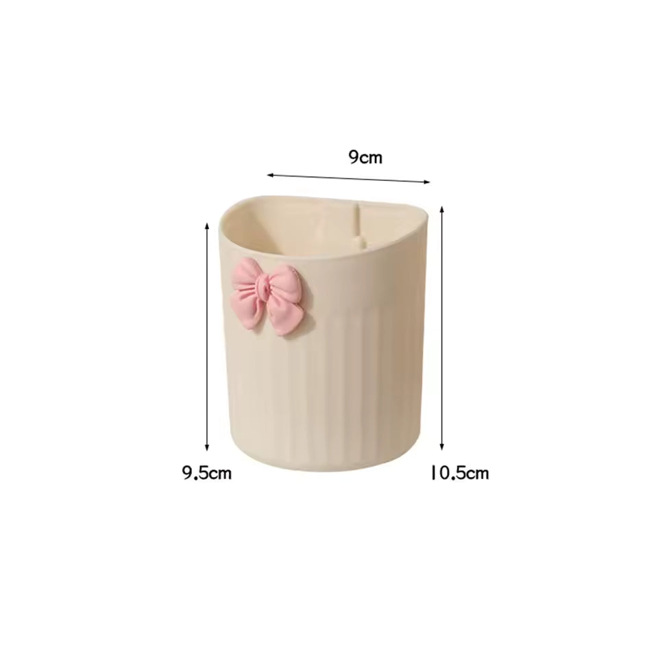 Kawaii pen holder for desk in beige with a pink bow detail measuring 9 by 10.5 centimeters