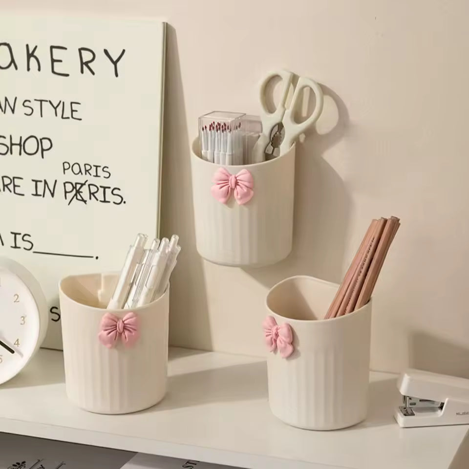 White kawaii pen holder for desk with pink bow design holding scissors, pencils, and pens