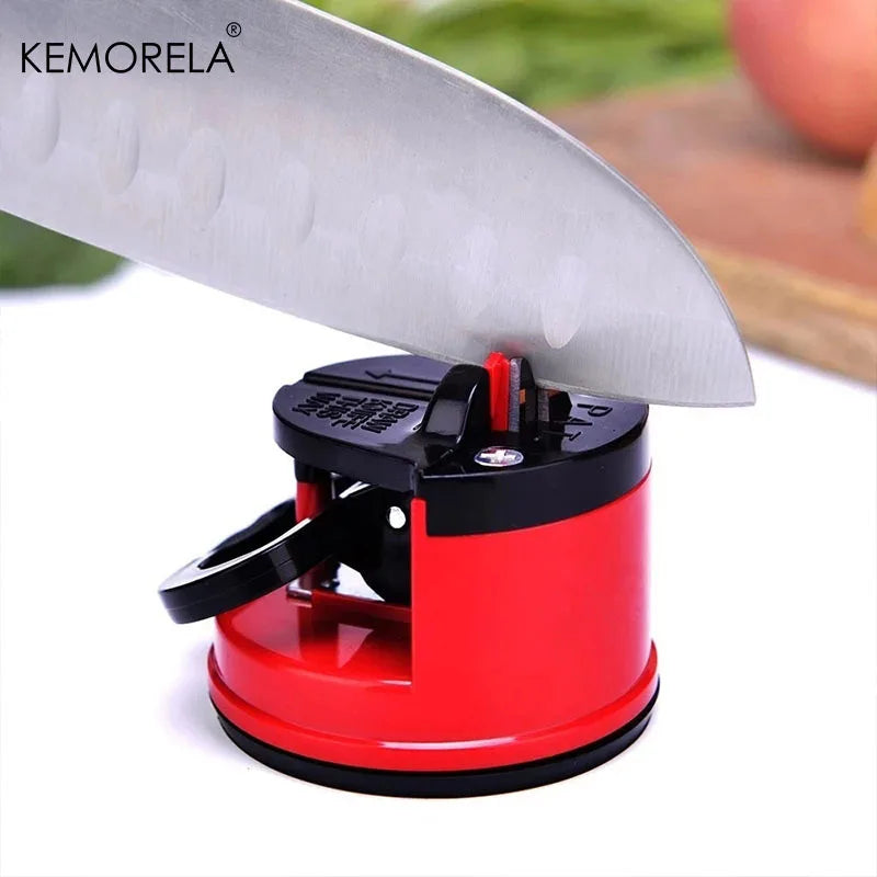 Red and black fine iron knife sharpener holding a large kitchen knife blade in use