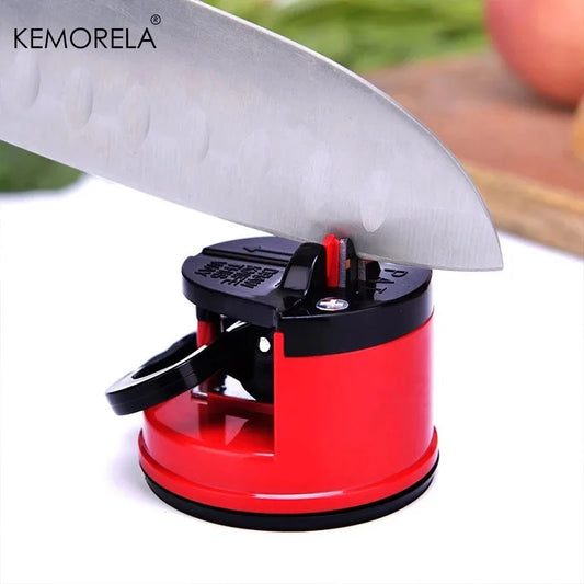 Red and black fine iron knife sharpener holding a large kitchen knife blade in use