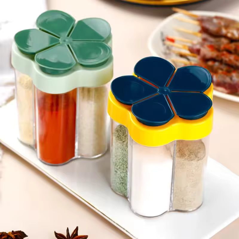 Clarify.pk kitchen seasoning container with lids in flower shape holding various spices on a white tray