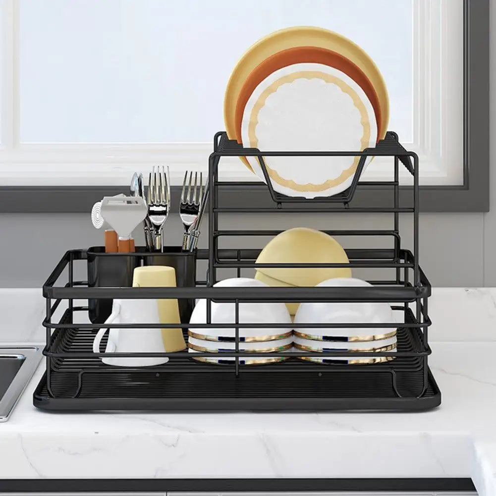 Black iron frame kitchen storage rack holding plates, cups, and cutlery on a white countertop