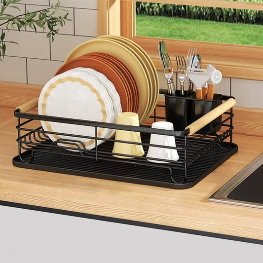 Black iron frame kitchen storage rack with wooden handle holding plates and utensils on countertop