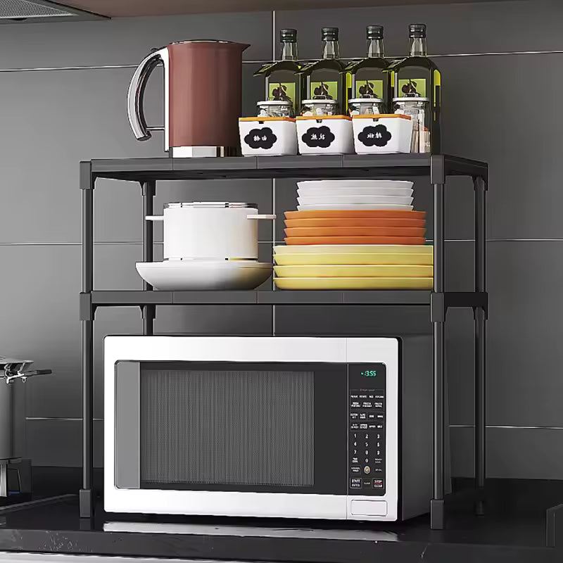 Clarify.pk kitchen storage rack organizer holding microwave, dishes, jars, and bottles on black countertop