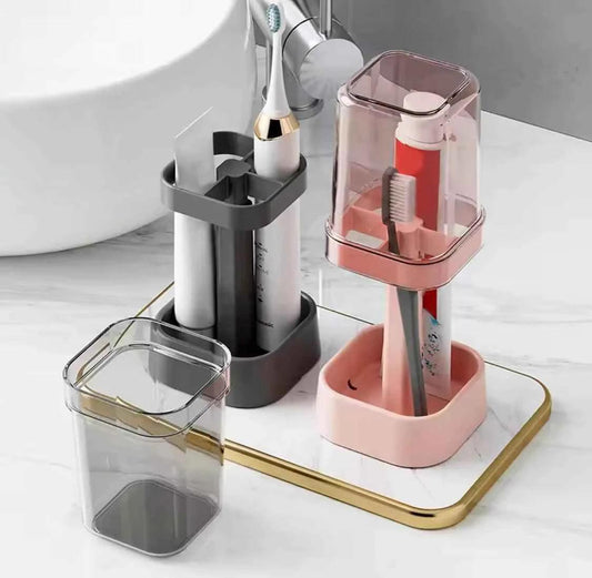 Lamp shaped toothbrush holder in pink and gray with transparent covers holding electric toothbrushes on bathroom counter