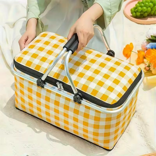 Large foldable picnic basket with yellow and white checkered pattern being held by hands