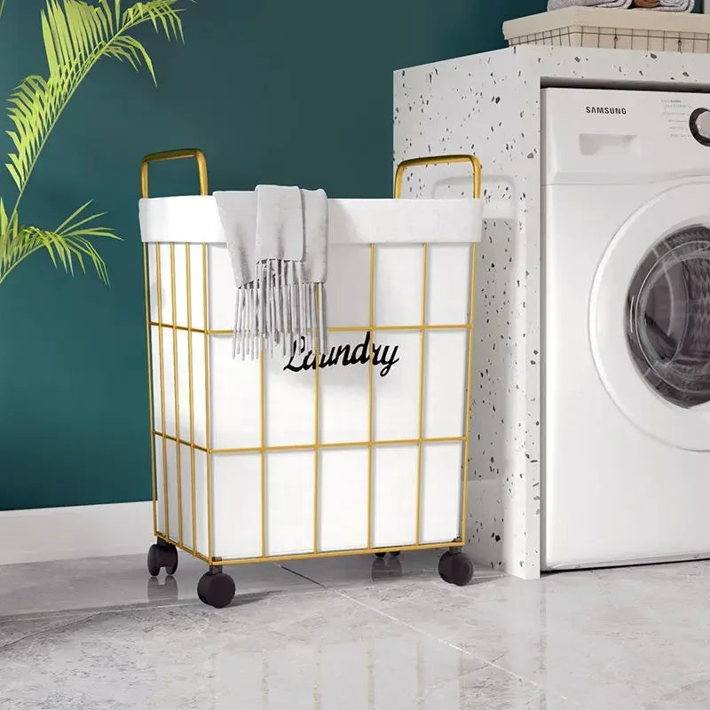 Clarify.pk laundry basket with wheels in white and gold metal frame placed near washing machine