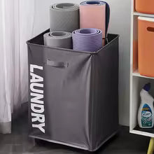 Clarify.pk gray laundry storage basket with handles holding rolled yoga mats in a bathroom