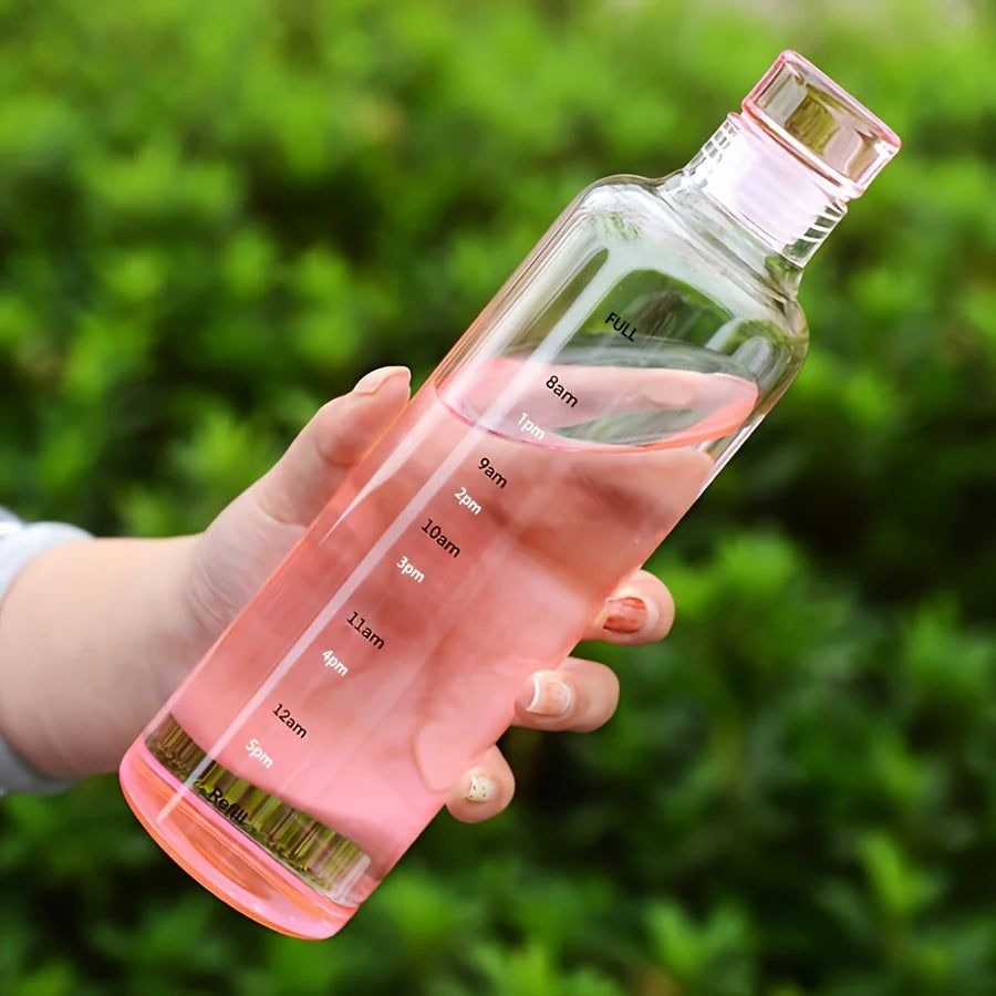 Clarify.pk leakproof sport water bottle with time marker and pink liquid held against green background