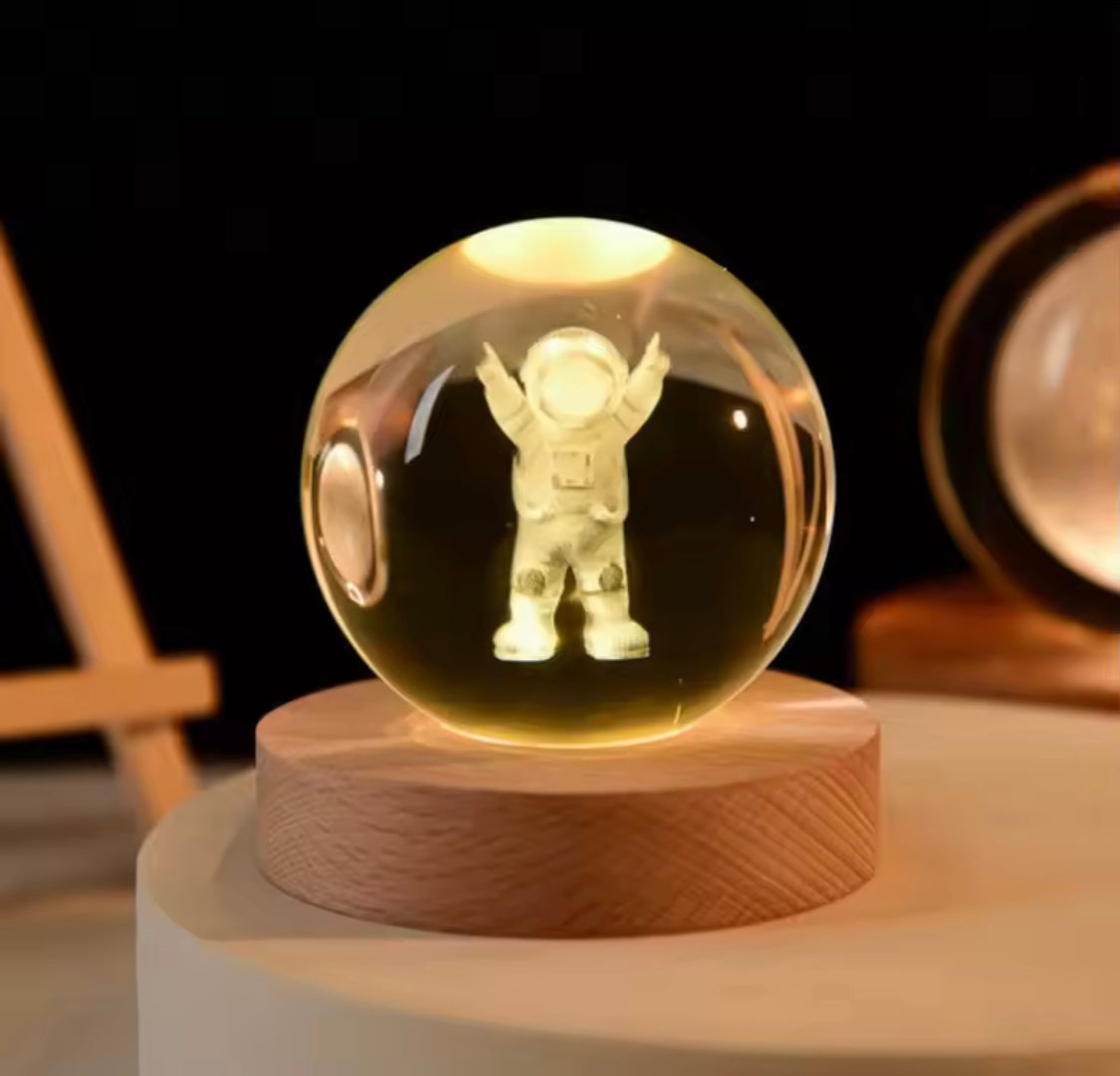 LED astronomy night light featuring a glowing astronaut figure inside a clear glass sphere on a wooden base