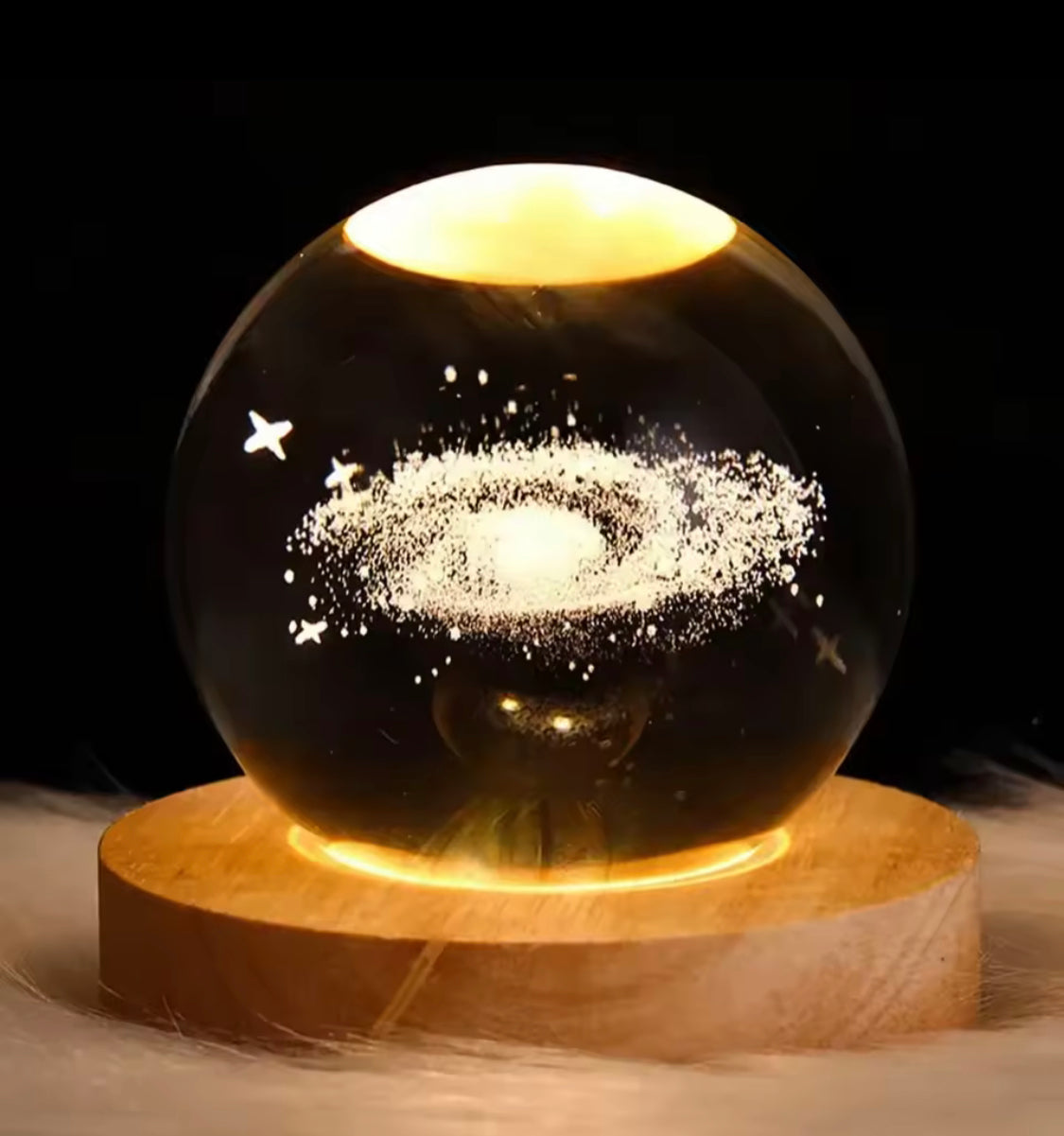 LED astronomy night light with galaxy design inside clear glass sphere on wooden base