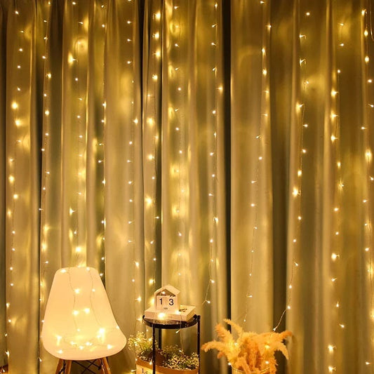 Warm white LED curtain lights for home decor hanging over beige curtains with chair and small table
