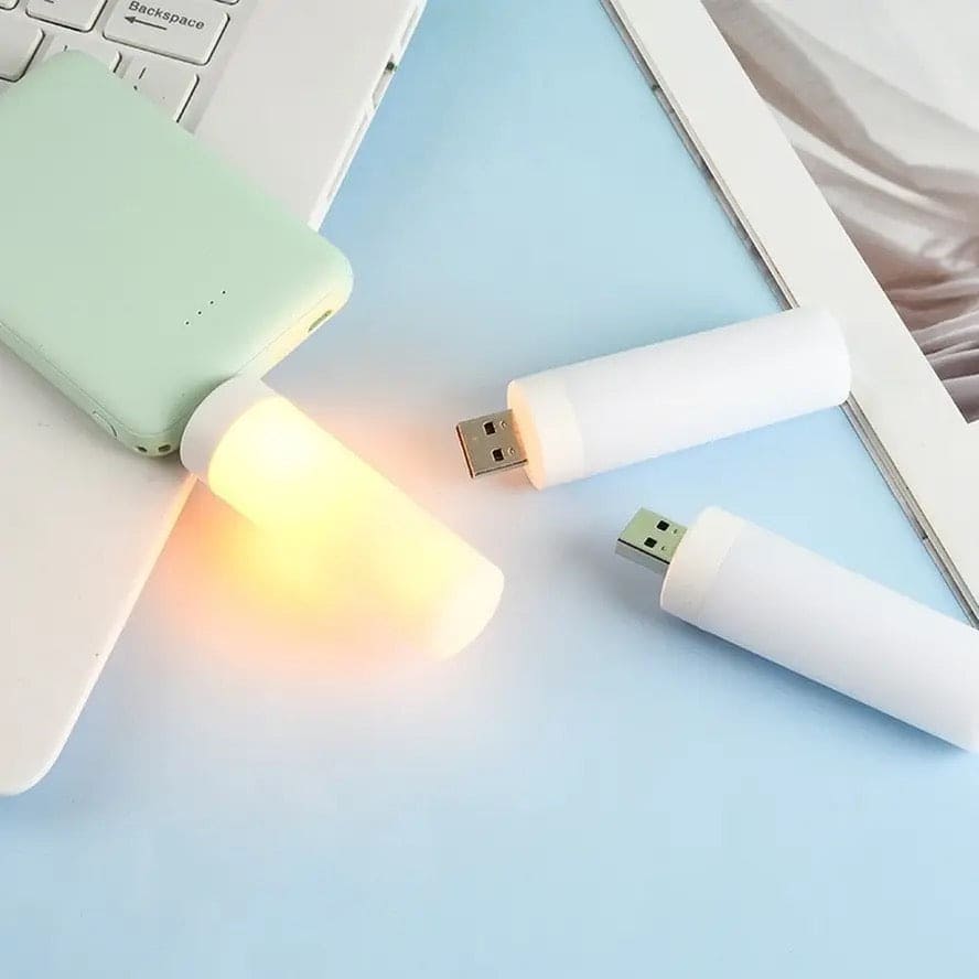Portable LED flame effect night light USB plug glowing warm yellow light on blue surface