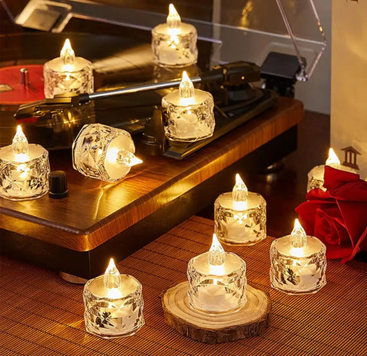 Set of decorative LED flameless candle lights with glass holders placed around a record player and wooden surface