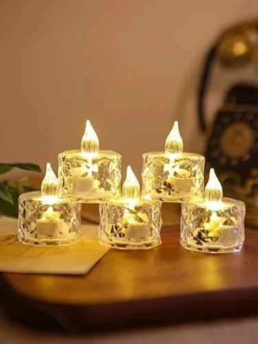 Set of five crystal LED flameless candle lights glowing warmly on a wooden table