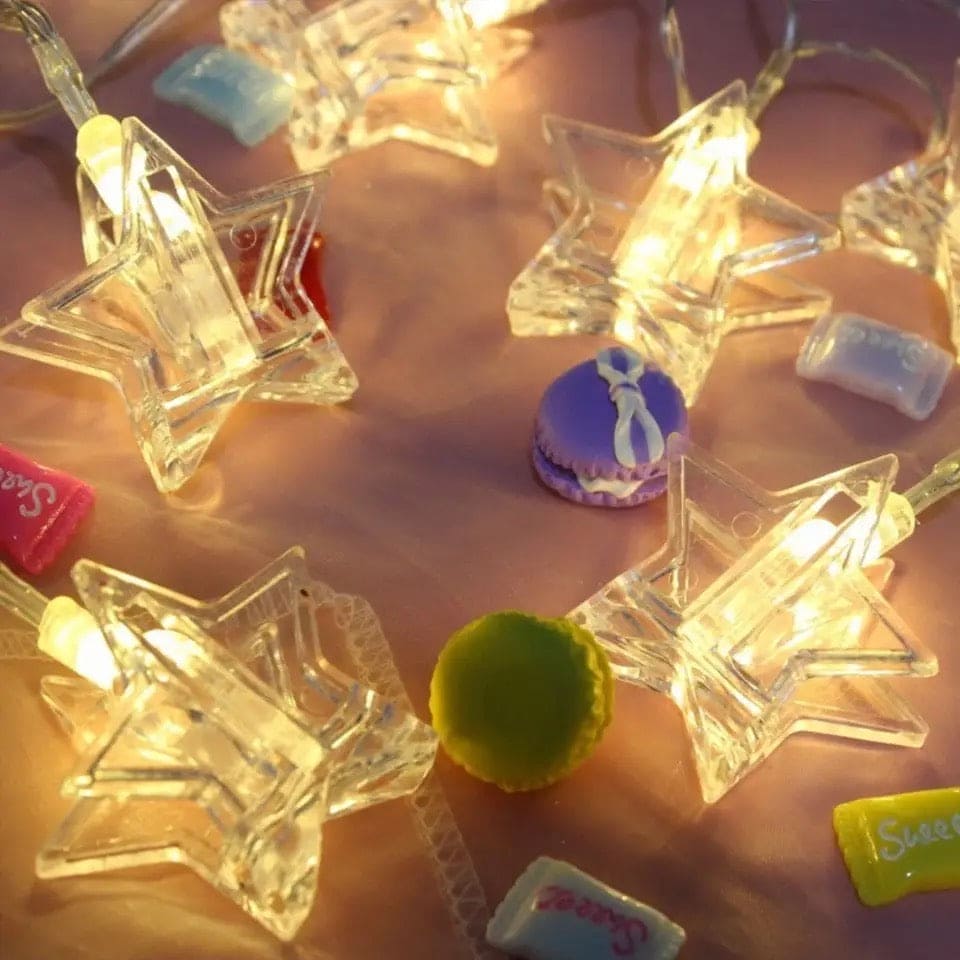 Star-shaped LED photo clip string lights glowing warmly on a decorative surface