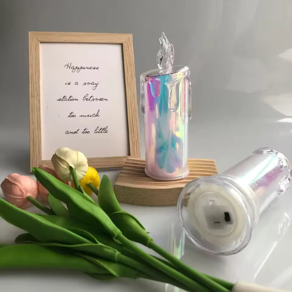 Clarify.pk LED pillar candle light with iridescent finish displayed on wooden stand beside artificial tulips and framed quote